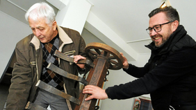 Foto: Hartmut Schwarz (Die Buge-Freunde Wolf-Dieter Blüthner und Lars Chrestensen (v.l.) bringen in der Ausstellung einen historischen Unkrautvernichter in Position.)